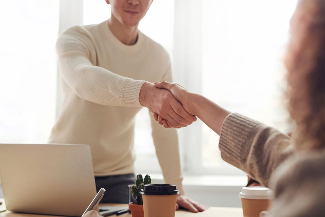 Two people greeting each other during a workplace conversation