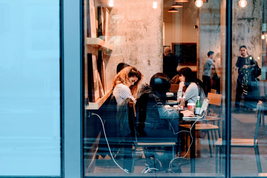 People working on laptops in a café.